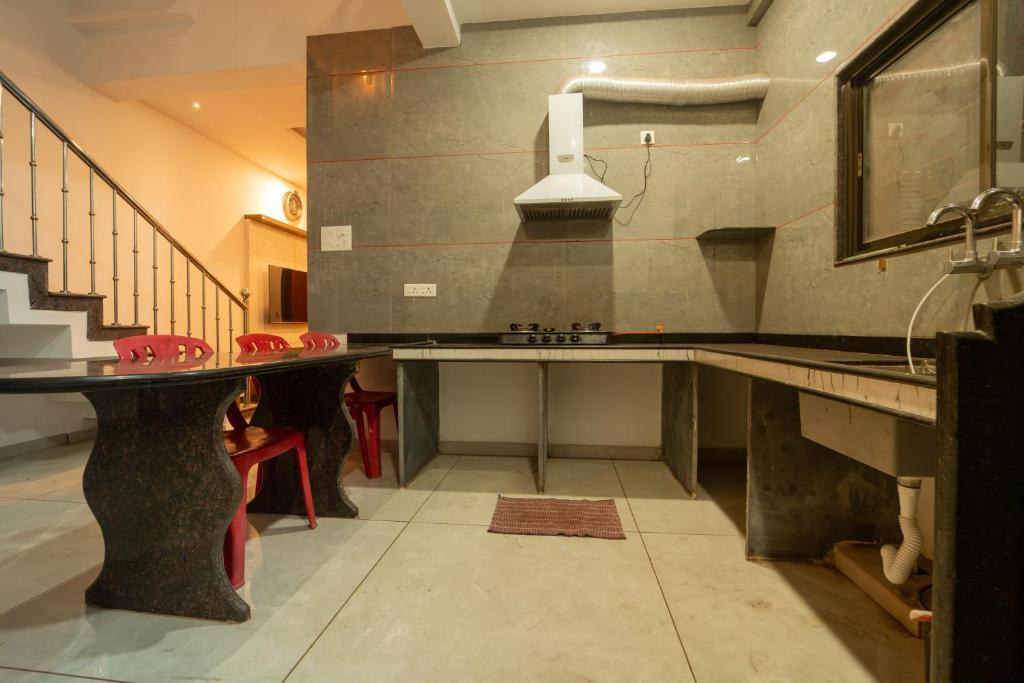 a kitchen with a counter and a sink and stairs at Babji villa in Kolhapur Airport
