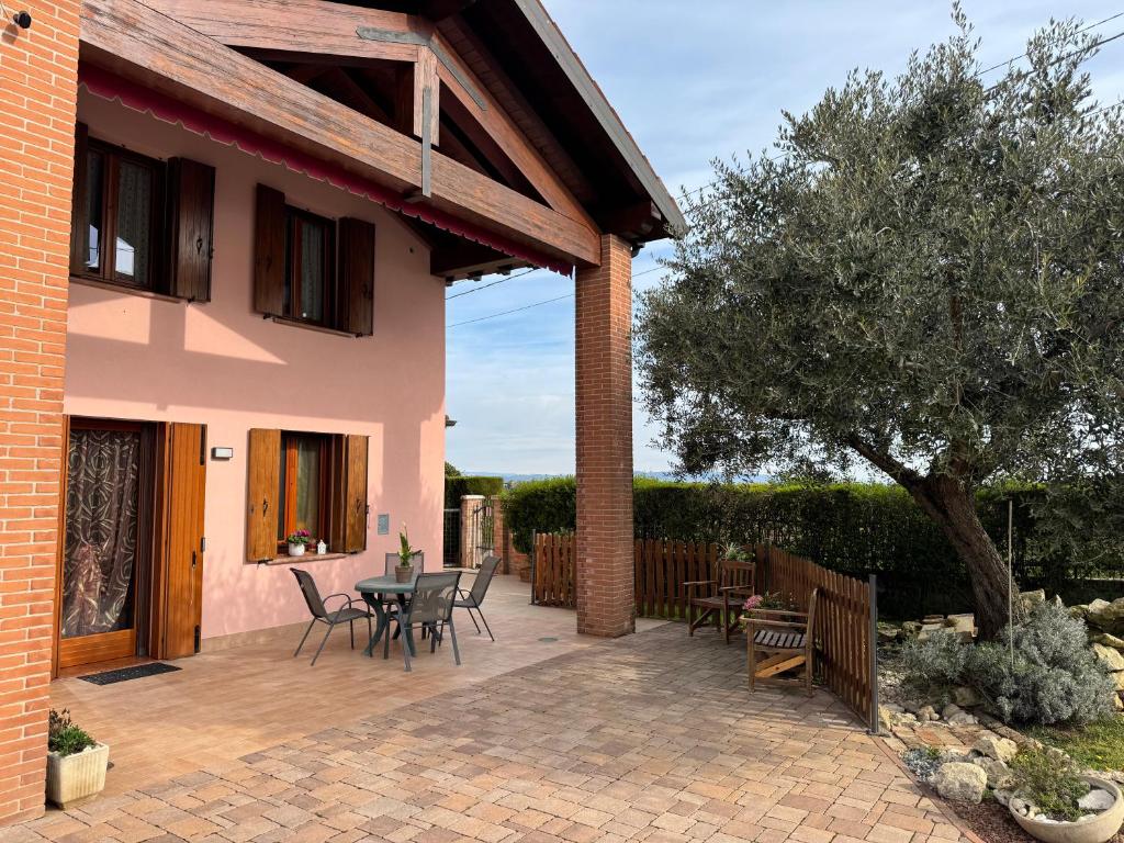 a patio of a house with a table and chairs at Il Giardino di Bronto-lo in Crosare