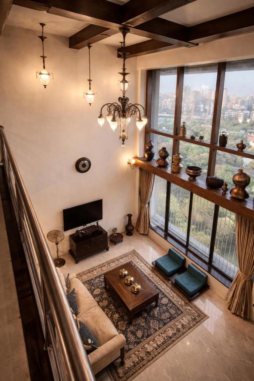 a living room with a couch and a table at Pet Friendly Spacious 3 BHK Penthouse in Mumbai