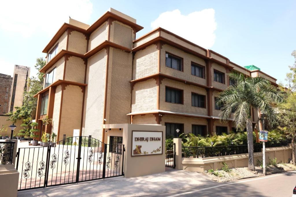 a building with a fence in front of it at Dhiraj Dham in Nāthdwāra