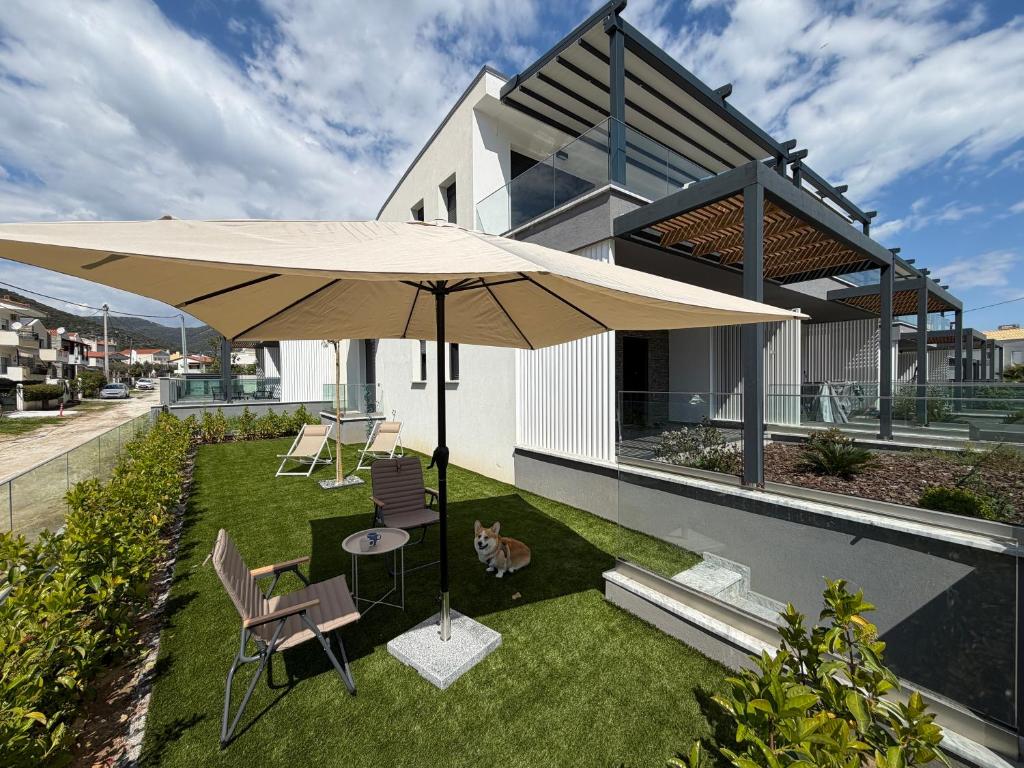 a patio with a table and a large umbrella at Aegean Grace Villa in Iraklitsa