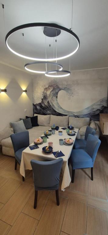 a dining room with a table and a large chandelier at Costa Blanca Międzyzdroje - Holiday Home in Międzyzdroje