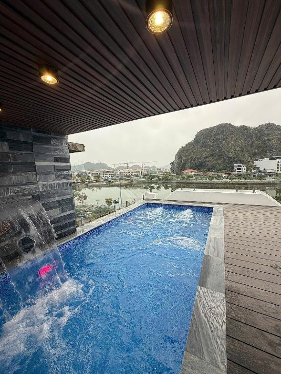 a swimming pool in a building with a water fall at Indocharm Villa Cat Ba in Cat Ba