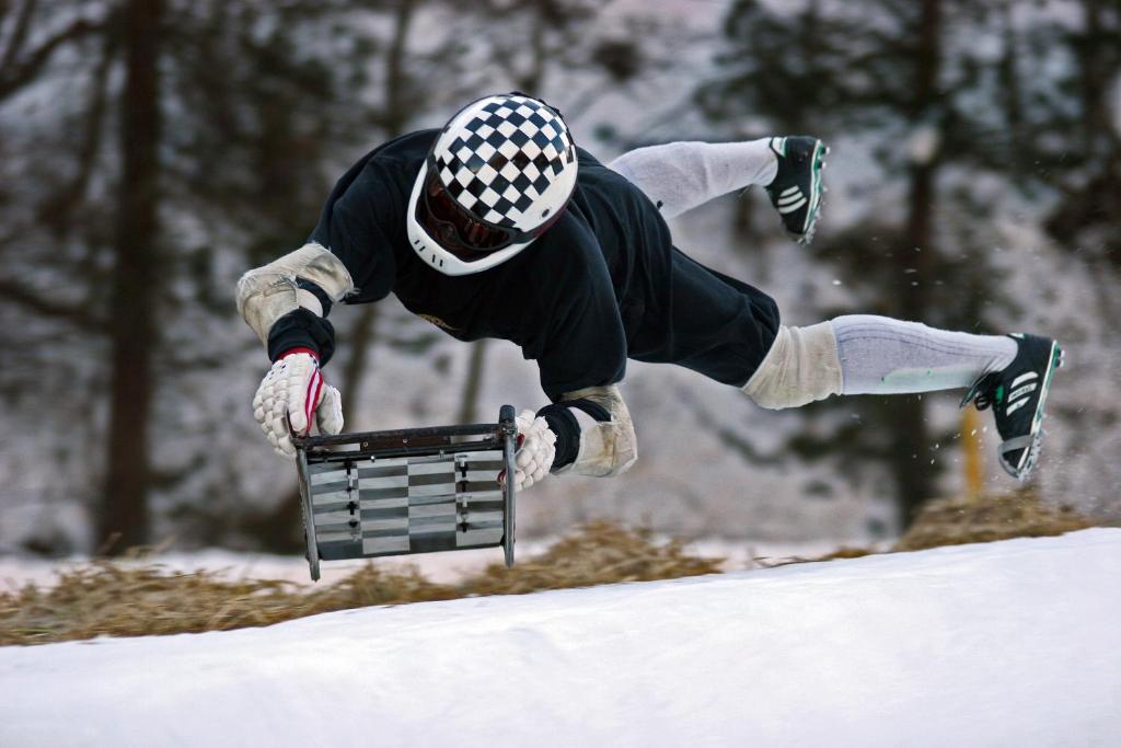 a person is jumping over a rail in the snow at Petit Steffani Bed & Breakfast in St. Moritz