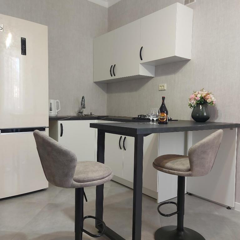 a kitchen with a black table and two chairs at Центр,дитяче містечко Казка in Mykolaiv