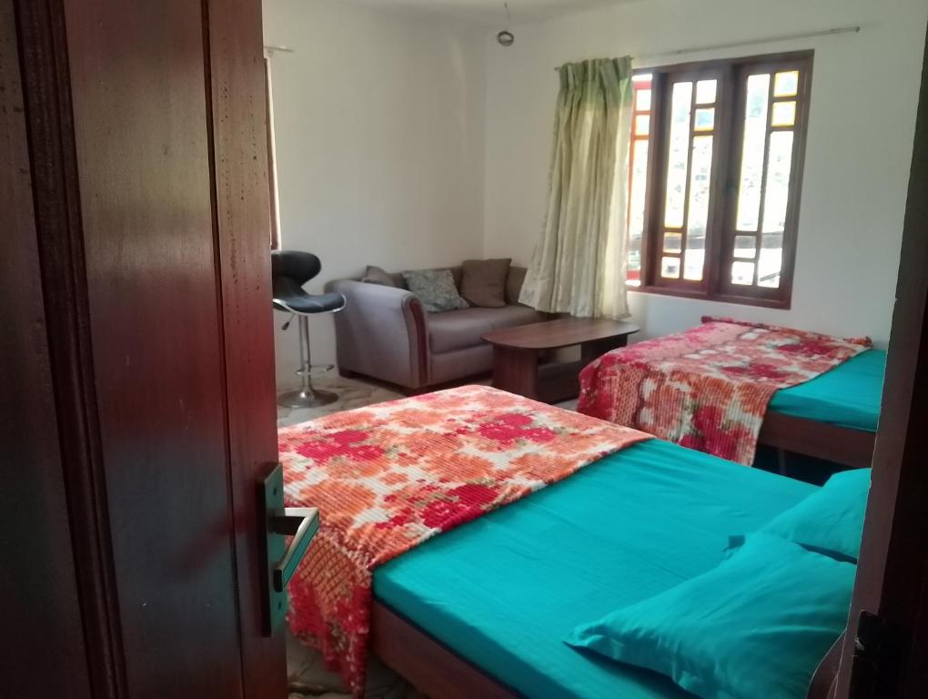 a living room with two beds and a couch at Oneli Homestay in Nuwara Eliya