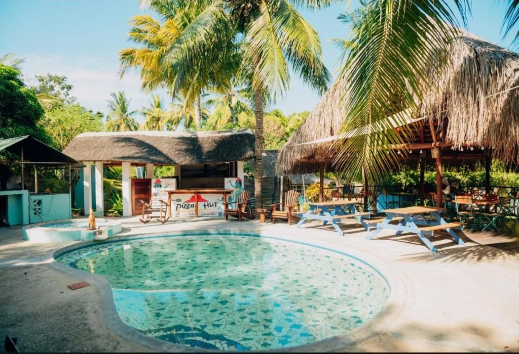 a swimming pool with chairs and a resort at Boa Gente Lodge in Vilanculos