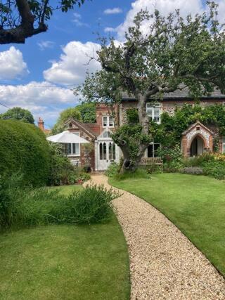 a large brick house with a gravel driveway at Stone Cottage in Thornage