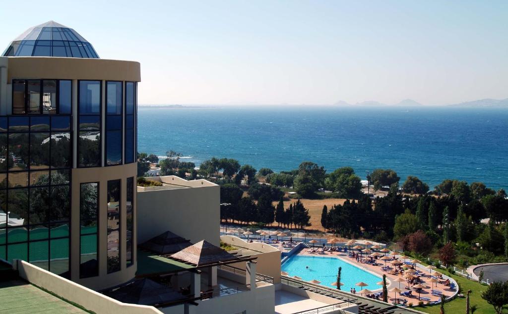 een uitzicht op een resort met een zwembad en de oceaan bij Kipriotis Panorama Hotel & Suites in Kos-stad