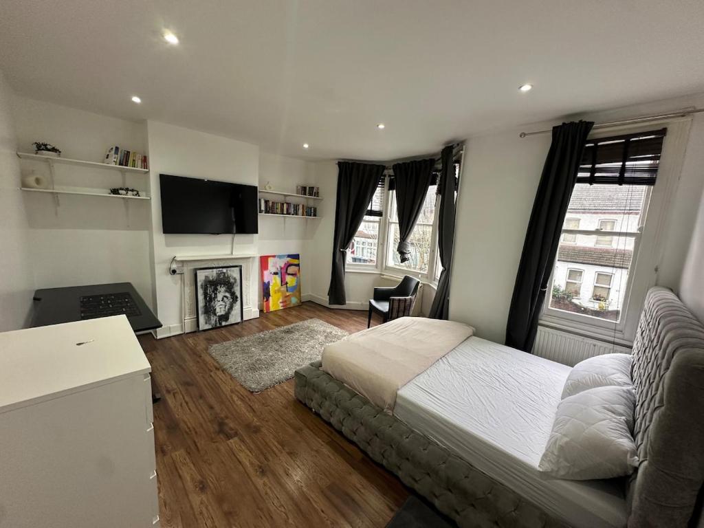 a bedroom with a bed and a fireplace at Massive cozy room with shared bathroom in Thornton Heath