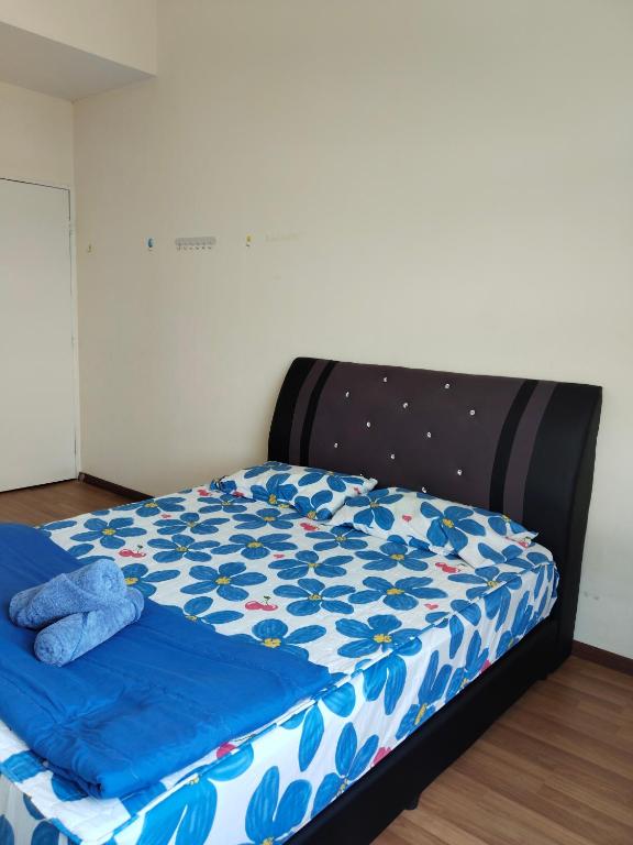 a bed in a room with a blue comforter at Seaview Emerald Sandakan in Sandakan