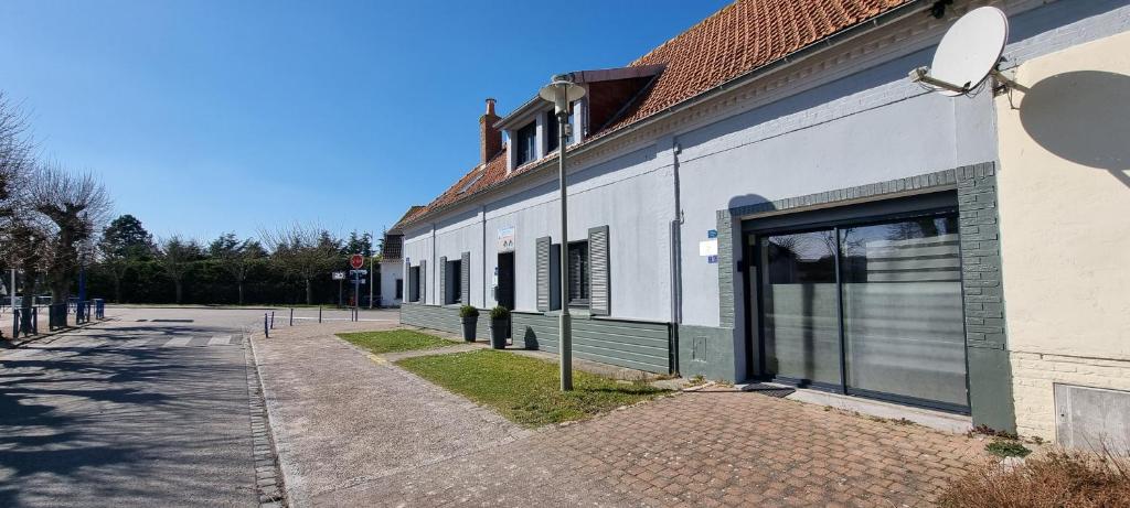 a white building with a door on the side of it at Aux Passagers de la Baie 2 Maison 3 Etoiles 2 couchages Terrasse Proche Mer Crotoy in Le Crotoy