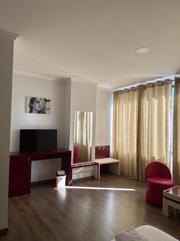 a living room with a television and a red chair at Ikea hotel in Kashari