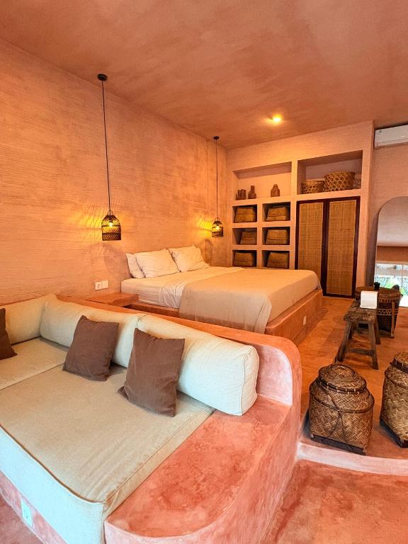 a bedroom with two beds and a couch at Le Bohémien Suites Cabana in Dalung