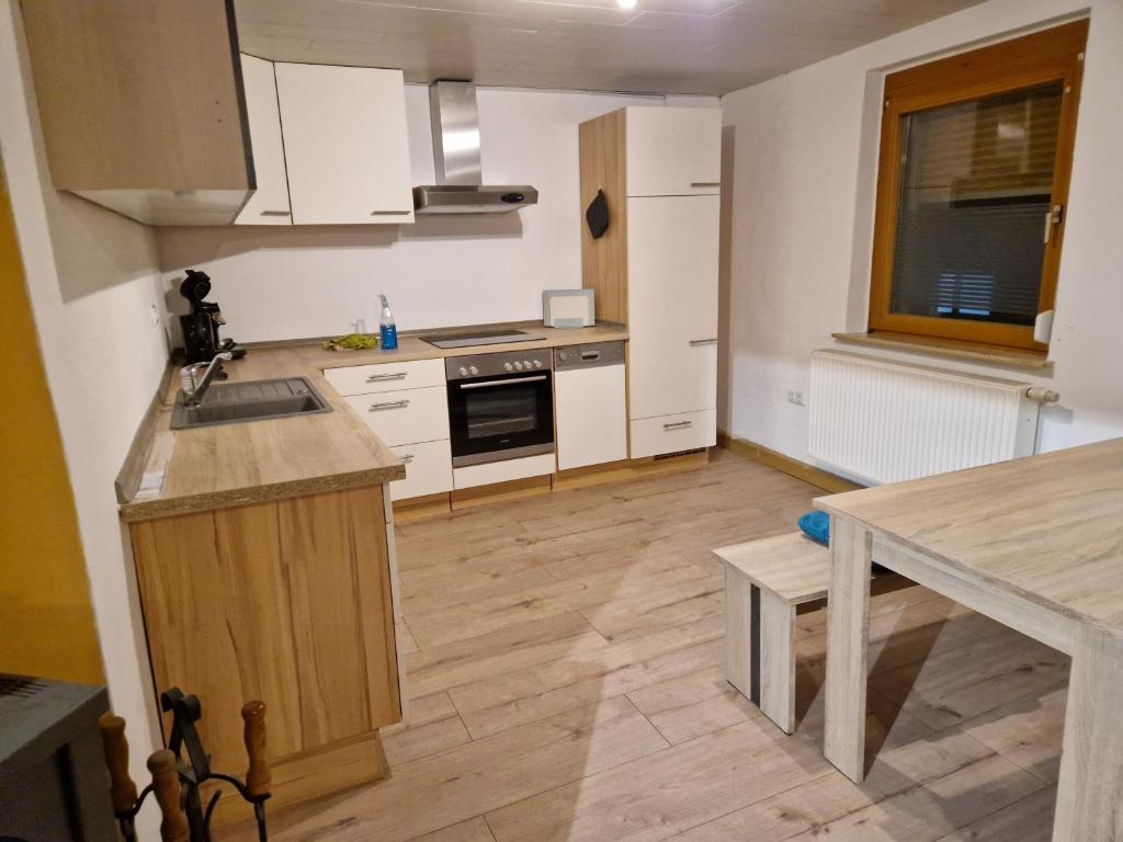 a kitchen with white cabinets and a wooden floor at Herzstück in Grafenrheinfeld