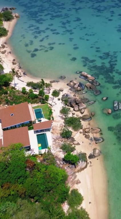 a group of elephants on a beach near the water at Fishman Beachfront Villas in Haad Pleayleam