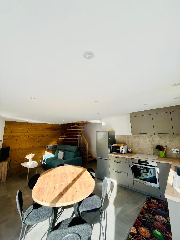 a kitchen and living room with a table and chairs at Chalet Douce Noire in Brides-les-Bains