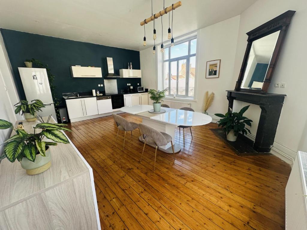 a living room with a table and a fireplace at Logement Océan in Boulogne-sur-Mer