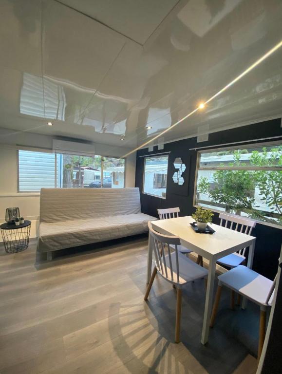 a bedroom with a bed and a table and chairs at Mobil-home dans un camping calme et familial chez César in Cambo-les-Bains