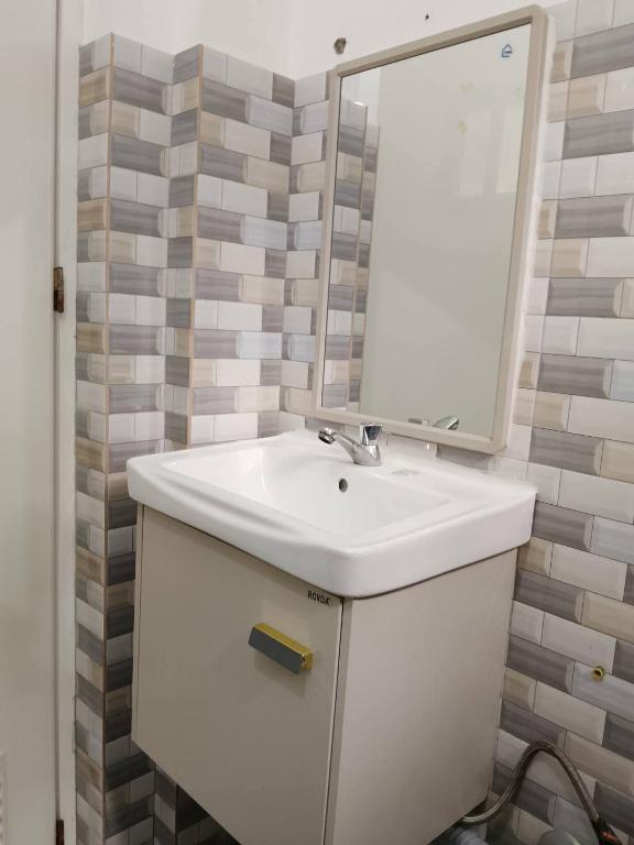 a bathroom with a white sink and a mirror at Candava's Residence in Puerto Galera