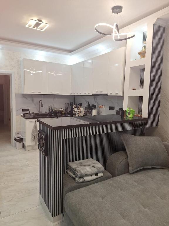 a kitchen with white cabinets and a couch in a room at ANY MARY Apart ZONA 0 in Tulcea