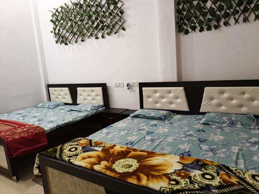 two beds in a room with two bedsitures at Sai holidays in Ayodhya