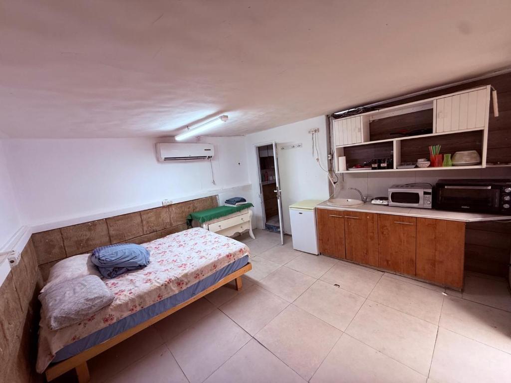 a small kitchen with a bed in a room at ברזיליאנו - Braziliano in Eilat