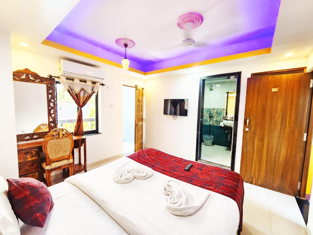 a bedroom with a bed and a desk at Casa Salvador in Calangute