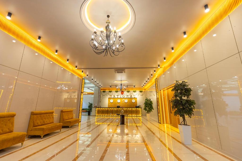 a lobby with a table and chairs and a chandelier at National Hotel Ganja in Ganja