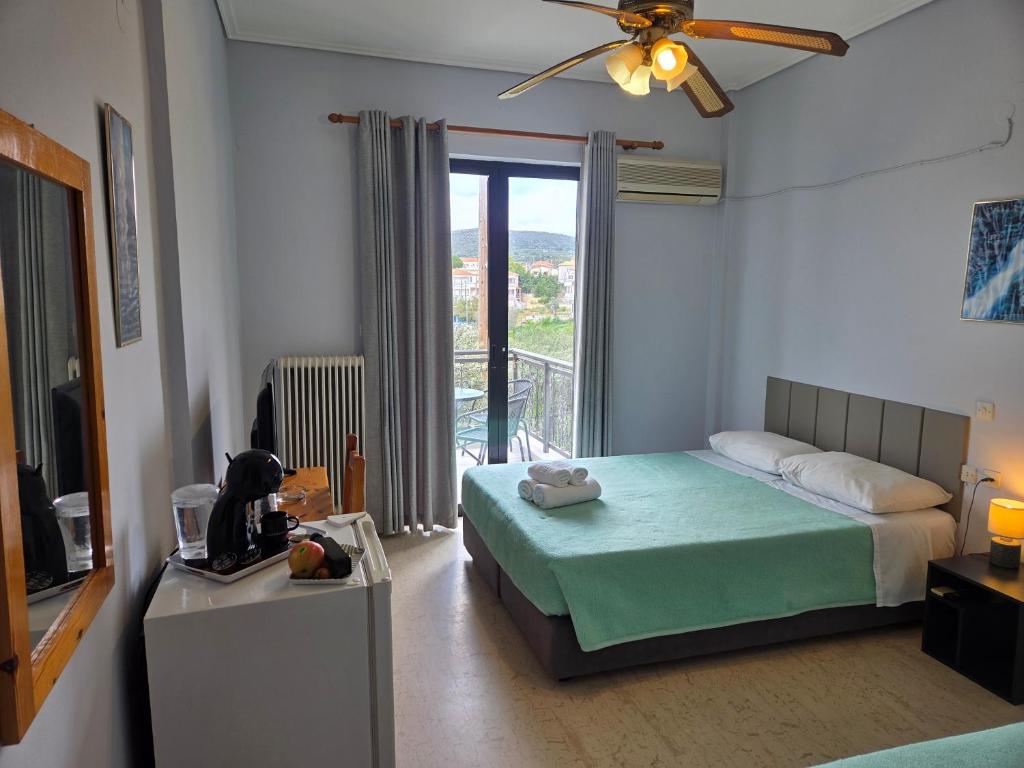 a bedroom with a bed and a television and a balcony at Elea rooms 7 in Elia Laconias