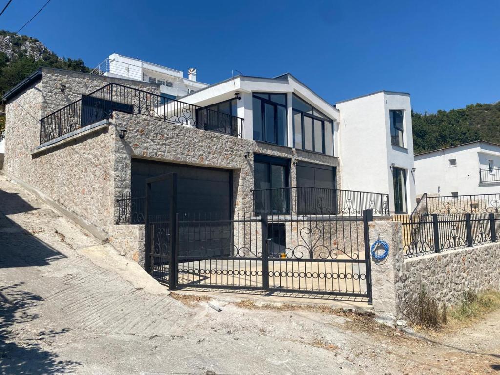 a stone house with a gate and a fence at Stone Villa in Zagrađe