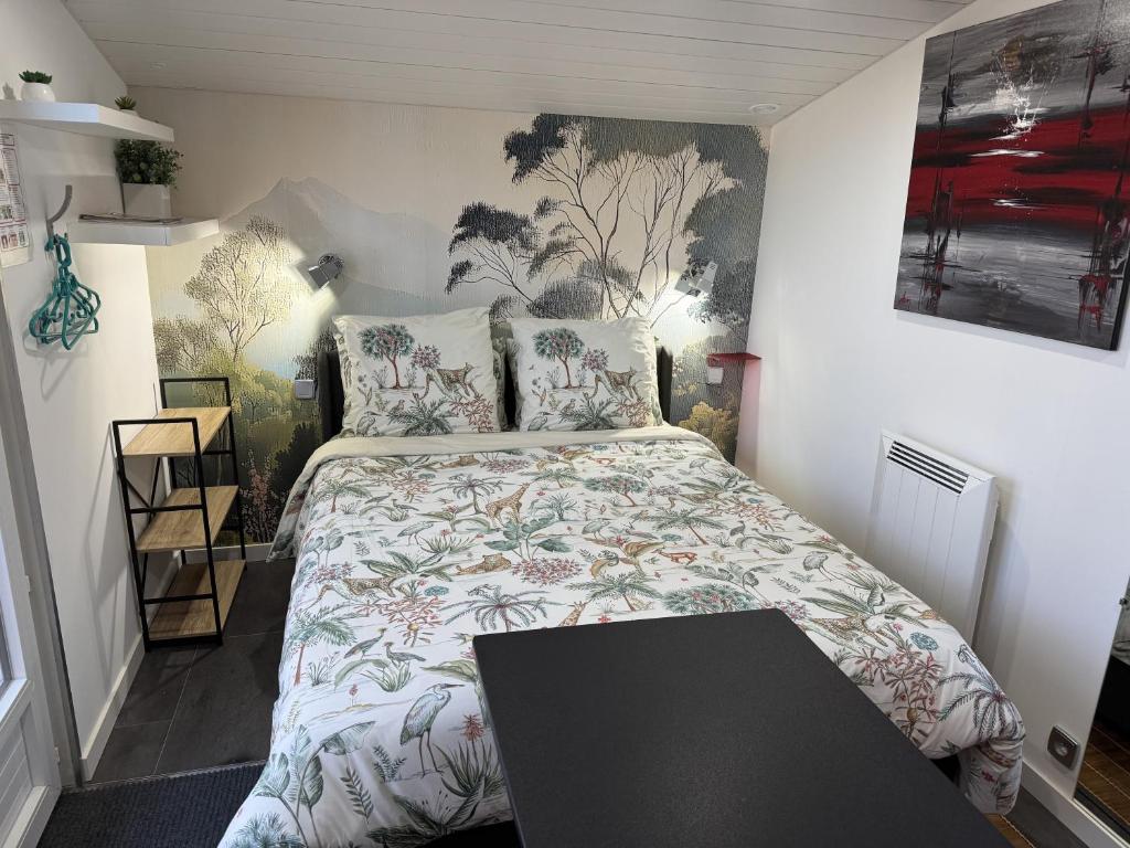 a small bedroom with a bed and a table at Domus26 Chambre Hortus in Montaigu-Vendée