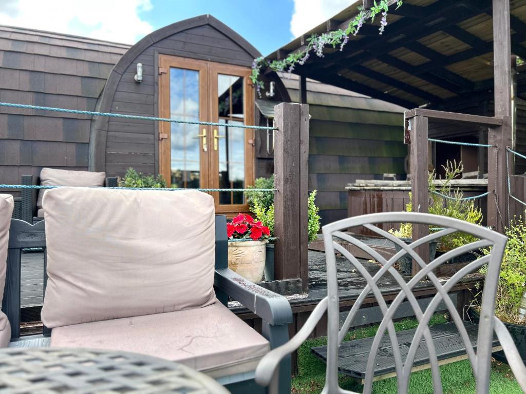 a patio with a chair and a pergola at Hatterall View Glamping Pod in Abergavenny