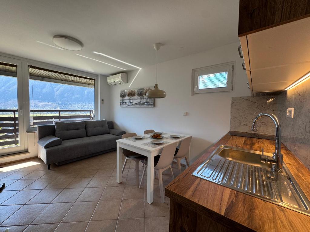 a kitchen and living room with a couch and a table at Apartment Planika Bovec in Bovec