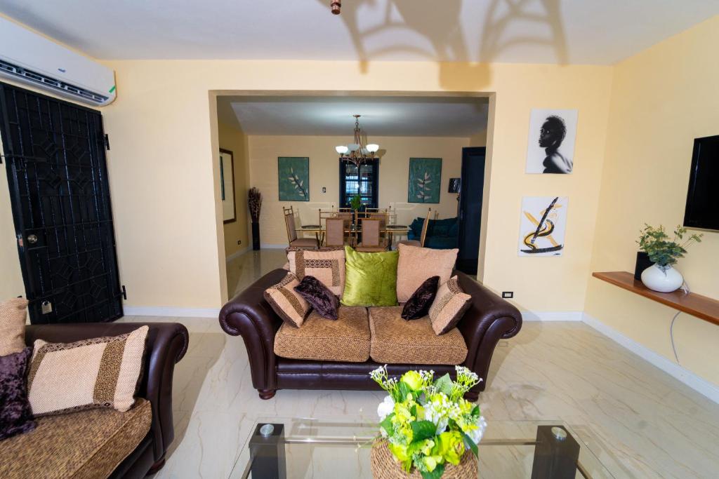 a living room with two couches and a table at Lagoon View Holiday Home in Montego Bay
