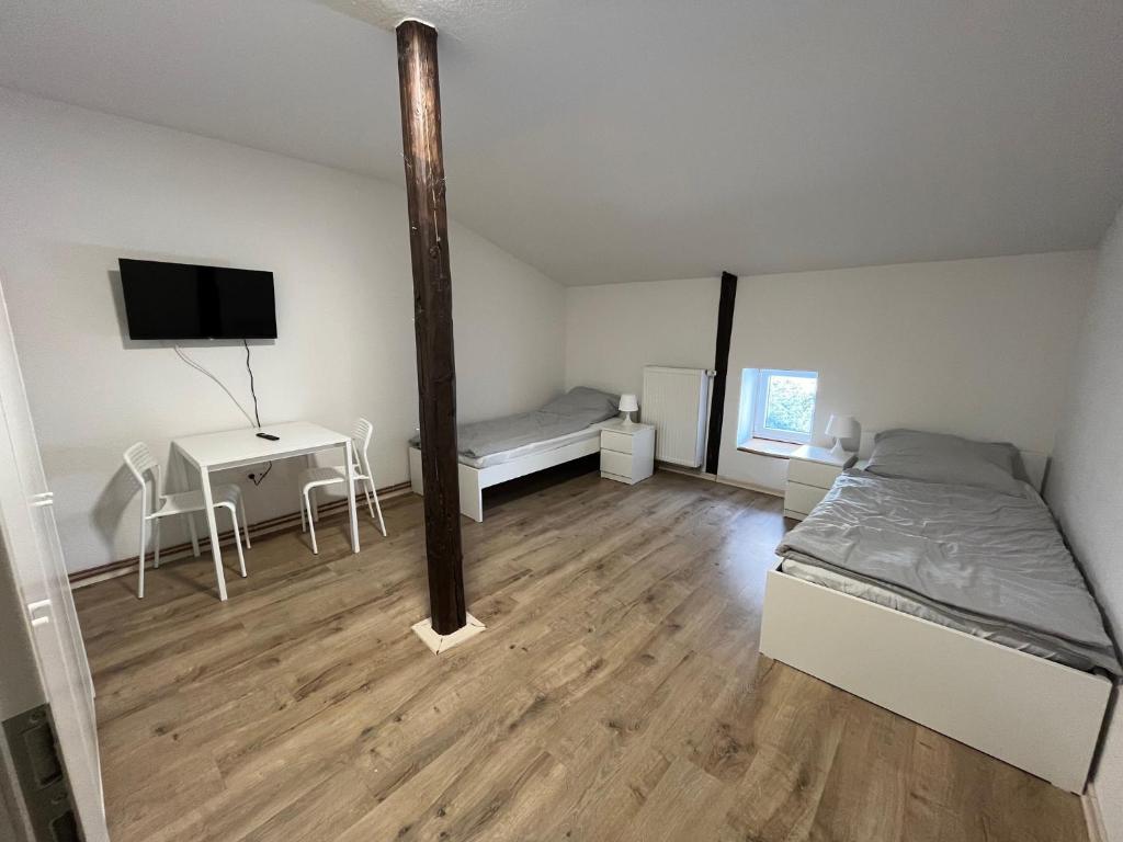 a room with a bed and a desk and a tv at Zweibettzimmer nah der A7 Tarp in Jerrishoe