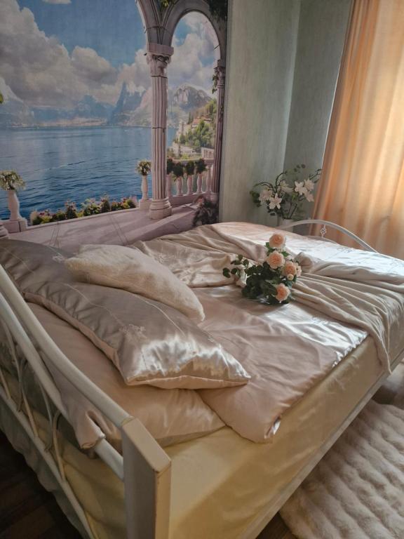 a bedroom with a bed with a painting on the wall at Ivory & Rose Studio in Tartu