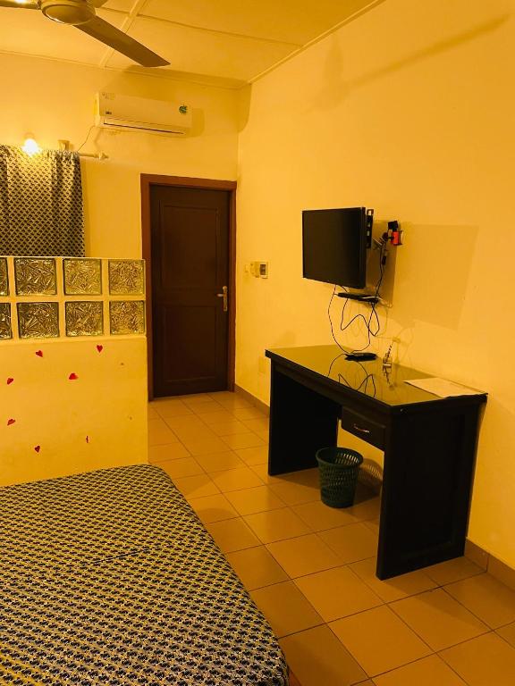 a room with a desk with a television on a wall at Agbevivi Boutique Hôtel in Aného