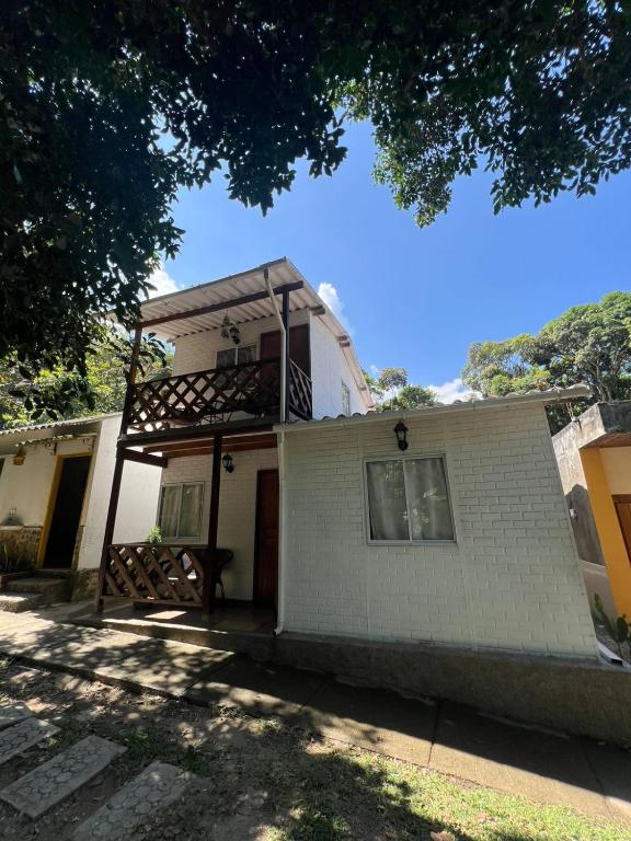 a white house with a balcony on top of it at Cabañas betania in Santa Marta