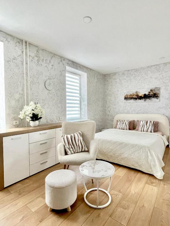 a bedroom with a bed and a chair and a table at Rami studio apartment in Panevėžys