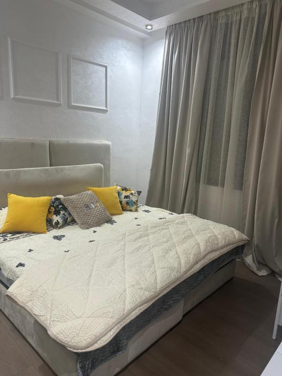 a bedroom with a bed with yellow pillows on it at Séjour chez habitant in Rabat