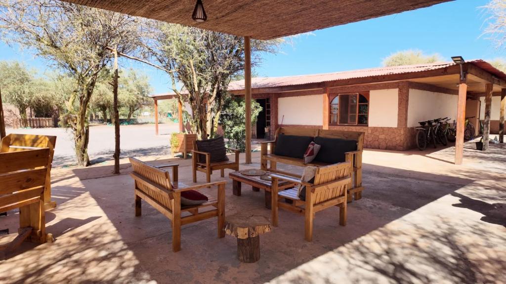 a patio with wooden benches and a house at El Rancho B&B in San Pedro de Atacama