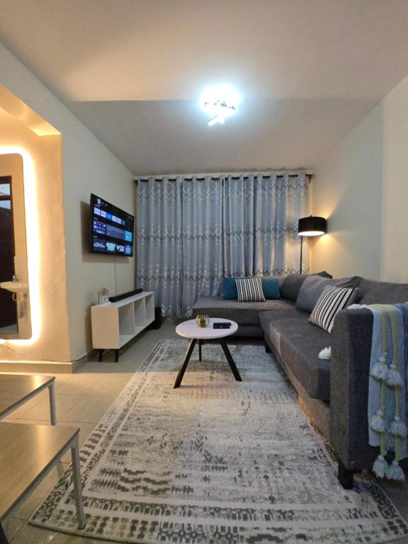a living room with a couch and a table at Mina Luxe Machakos in Machakos
