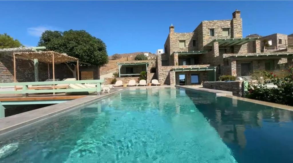 a swimming pool in front of a house at Sea & Stone Villas in Koundouros