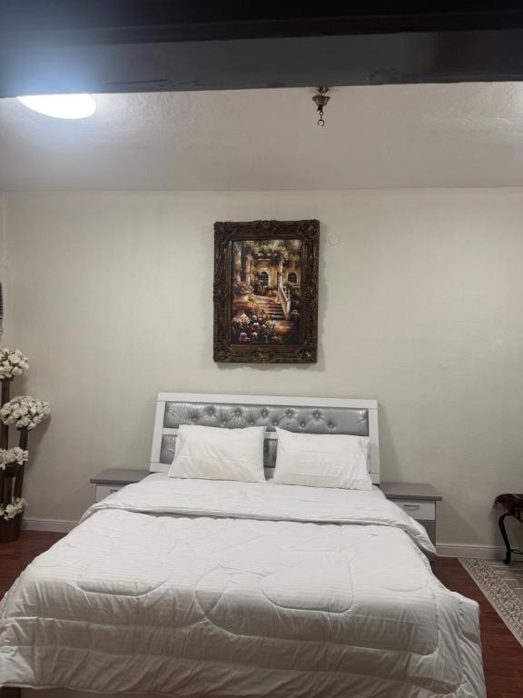 a bedroom with a large bed with a painting on the wall at رفيف باريس نجد in Unayzah