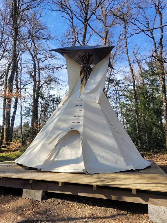 a tent sitting on top of a wooden platform at TIPIsche trekkershut - Camping Le Soustran in Neuvic