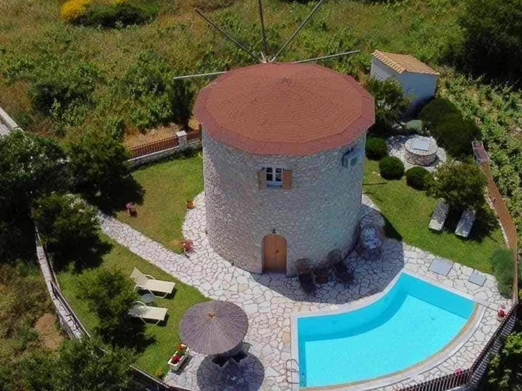 an aerial view of a building with a swimming pool at Anemomilos Villa in Asprogerakata
