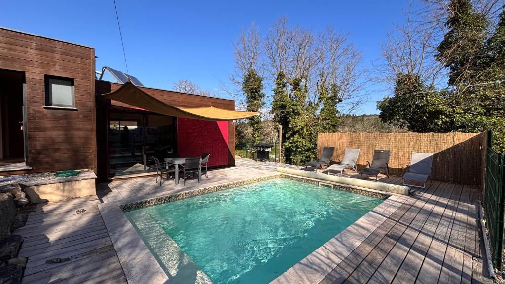 a swimming pool in front of a house at Villa Les Vignes in Salavas