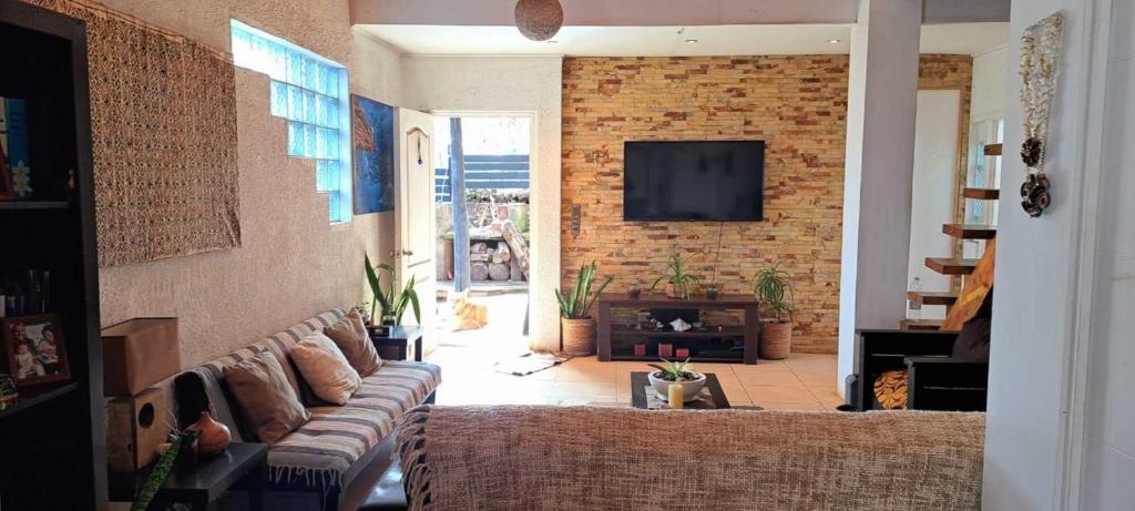 a living room with a couch and a brick wall at Hare Te Maori in Hanga Roa