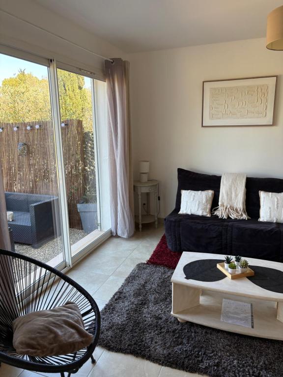 a living room with a couch and a coffee table at Appartement Romana PUISSALICON 34 in Puissalicon